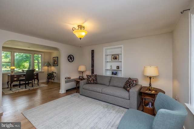 1034-1040 Twin County Rd, Honey Brook, PA 19344 - living room with arched walkways, wood finished floors, built in features, radiator, and baseboards