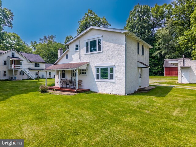 1034-1040 Twin County Rd, Honey Brook, PA 19344 - rear view of property with stucco siding, a yard, an outbuilding, and a deck