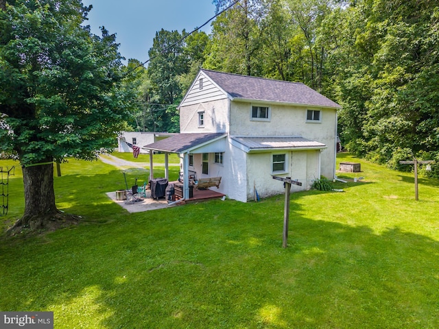 1034-1040 Twin County Rd, Honey Brook, PA 19344 - back of property featuring stucco siding, a patio area, a yard, metal roof, and a standing seam roof