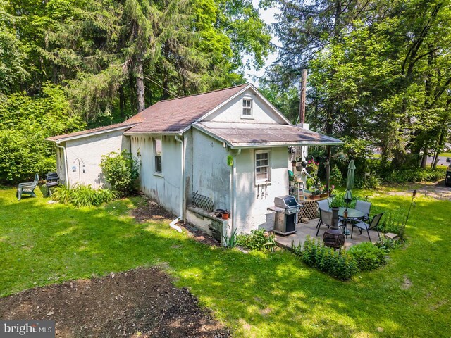 1034-1040 Twin County Rd, Honey Brook, PA 19344 - view of property exterior featuring a yard, a patio area, stucco siding, and roof with shingles