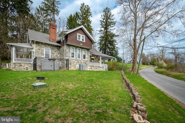00 Devereux Rd, Glenmoore, PA 19343 - back of property with stone siding, a chimney, a lawn, and covered porch