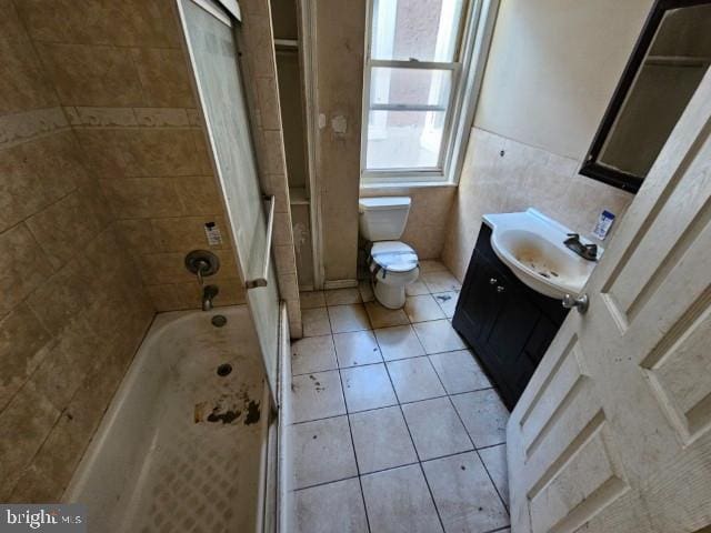 634 N 56th St, Philadelphia, PA 19131 - bathroom featuring vanity, tile patterned flooring, toilet, tile walls, and bathtub / shower combination