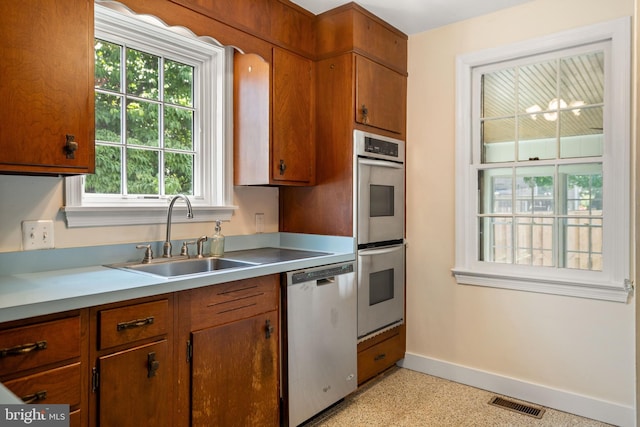 5600 11th St N, Arlington, VA 22205 - kitchen with appliances with stainless steel finishes, a sink, baseboards, and brown cabinets