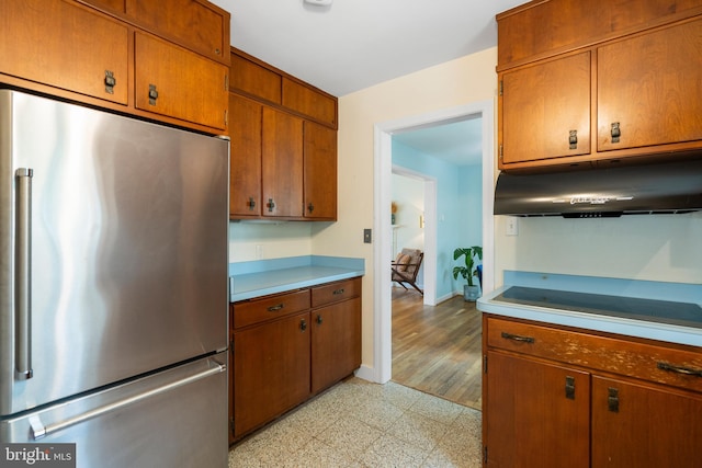 5600 11th St N, Arlington, VA 22205 - kitchen featuring freestanding refrigerator, extractor fan, light countertops, brown cabinets, and baseboards