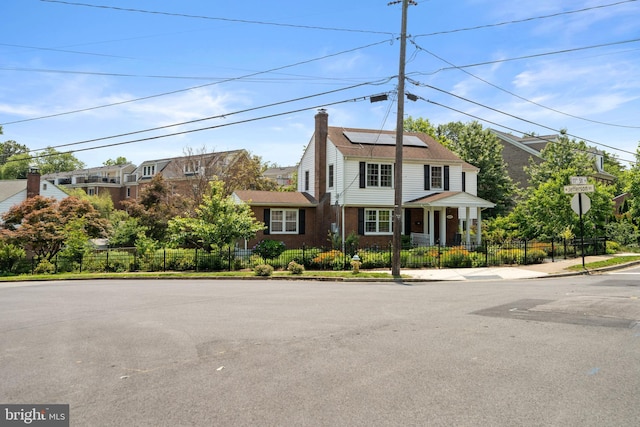 5600 11th St N, Arlington, VA 22205 - view of front of home featuring roof mounted solar panels, a chimney, and brick siding