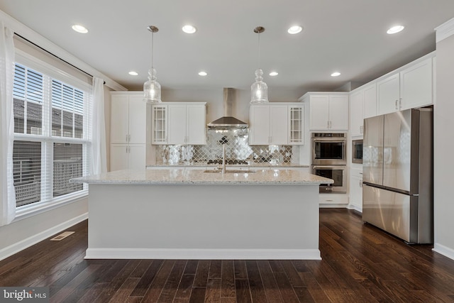 22277 Foggy Ridge Ter, Ashburn, VA 20148 - kitchen with wall chimney range hood, stainless steel appliances, a center island with sink, dark wood-style floors, and recessed lighting
