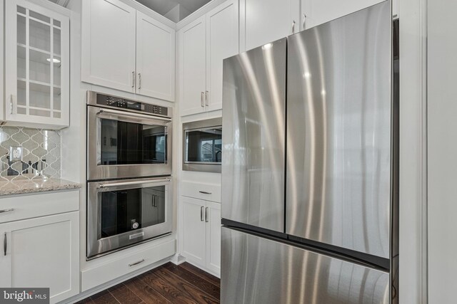 22277 Foggy Ridge Ter, Ashburn, VA 20148 - kitchen with stainless steel appliances, glass insert cabinets, dark wood-style floors, white cabinets, and light stone counters