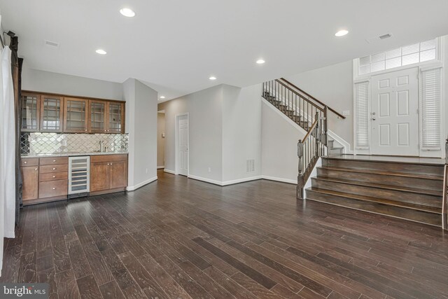 22277 Foggy Ridge Ter, Ashburn, VA 20148 - unfurnished living room with beverage cooler, stairs, dark wood finished floors, baseboards, and recessed lighting