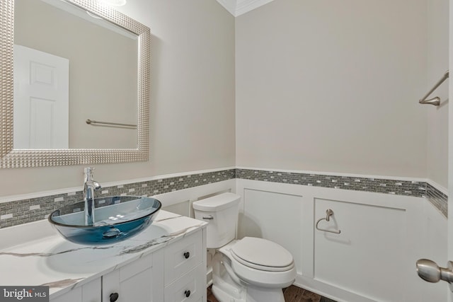 22277 Foggy Ridge Ter, Ashburn, VA 20148 - bathroom with tile walls, toilet, vanity, a wainscoted wall, and crown molding