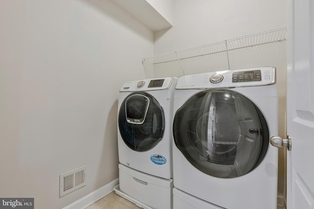 22277 Foggy Ridge Ter, Ashburn, VA 20148 - laundry area featuring washing machine and dryer, baseboards, and light tile patterned floors