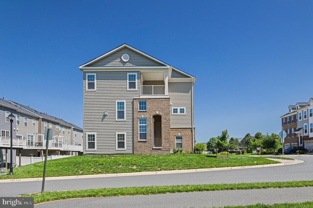 22277 Foggy Ridge Ter, Ashburn, VA 20148 - view of front facade featuring brick siding, a front yard, a residential view, and a balcony