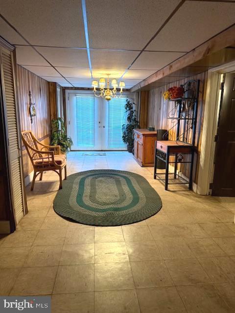 7316 Pittville Ave, Philadelphia, PA 19126 - welcome area with wood walls, a drop ceiling, a chandelier, and french doors