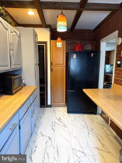 7316 Pittville Ave, Philadelphia, PA 19126 - kitchen featuring freestanding refrigerator, stainless steel microwave, light countertops, coffered ceiling, and beam ceiling