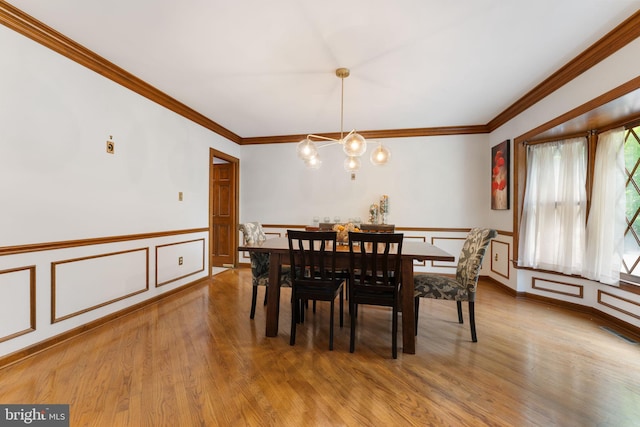15713 Holly Grove Rd, Silver Spring, MD 20905 - dining space with light wood-style floors, wainscoting, crown molding, a decorative wall, and a chandelier
