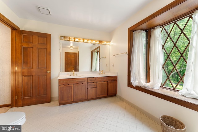 15713 Holly Grove Rd, Silver Spring, MD 20905 - full bath featuring healthy amount of natural light, double vanity, baseboards, and toilet