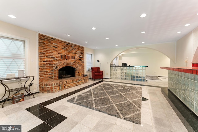 15713 Holly Grove Rd, Silver Spring, MD 20905 - unfurnished living room featuring inlaid floor details, recessed lighting, a brick fireplace, baseboards, and arched walkways