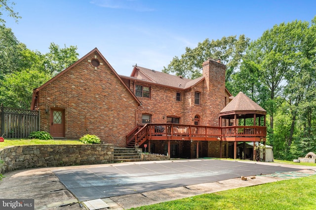 15713 Holly Grove Rd, Silver Spring, MD 20905 - back of house featuring a gazebo, a chimney, brick siding, and a deck