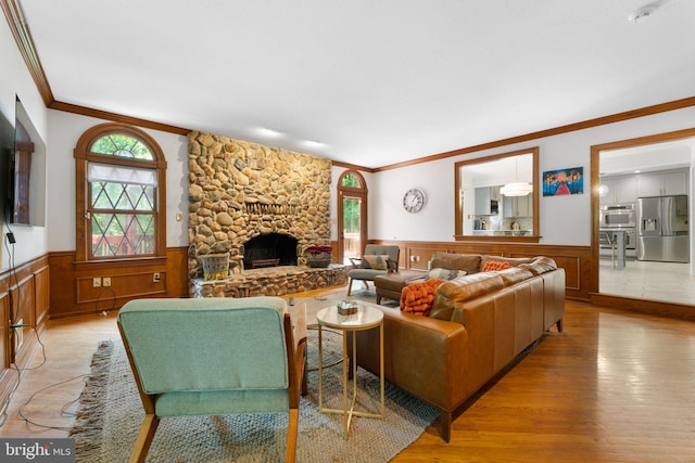 15713 Holly Grove Rd, Silver Spring, MD 20905 - living room featuring crown molding, a wainscoted wall, healthy amount of natural light, light wood-type flooring, and a fireplace