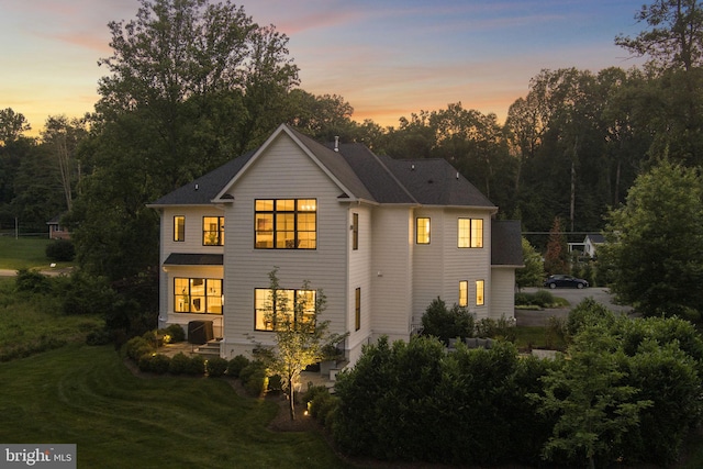 717 Miller Ave, Great Falls, VA 22066 - back of property at dusk with a lawn and a patio