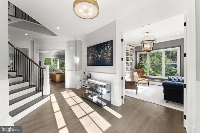 717 Miller Ave, Great Falls, VA 22066 - entryway with a decorative wall, crown molding, a chandelier, stairway, and wood finished floors