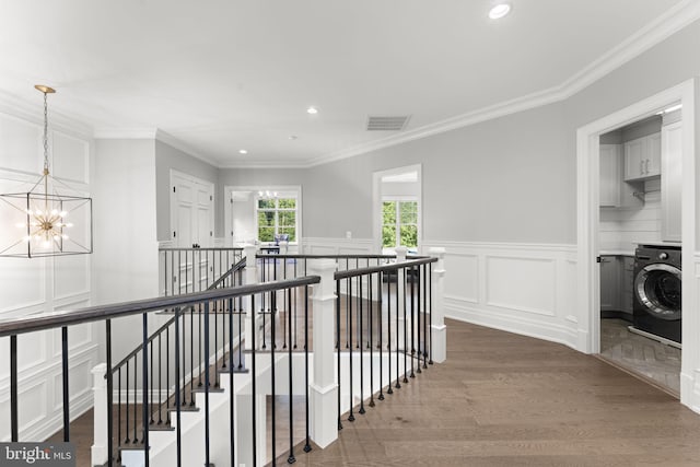 717 Miller Ave, Great Falls, VA 22066 - hall with an upstairs landing, washer / clothes dryer, a chandelier, wood finished floors, and ornamental molding