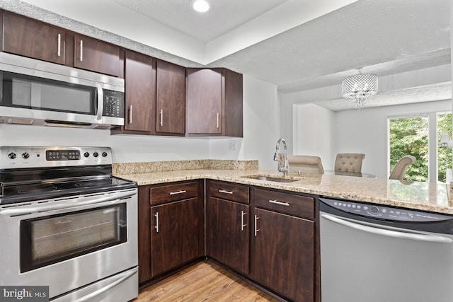 13825 Palmer House Way Unit 32-237, Silver Spring, MD 20904 - kitchen with stainless steel appliances, light wood-type flooring, light stone countertops, and a chandelier