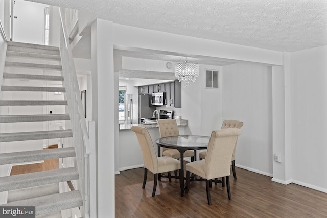 13825 Palmer House Way Unit 32-237, Silver Spring, MD 20904 - dining room featuring stairway, dark wood-type flooring, a chandelier, and a textured ceiling
