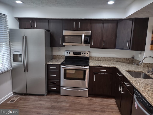13825 Palmer House Way Unit 32-237, Silver Spring, MD 20904 - kitchen featuring stainless steel appliances, a sink, dark brown cabinets, dark wood-type flooring, and light stone countertops