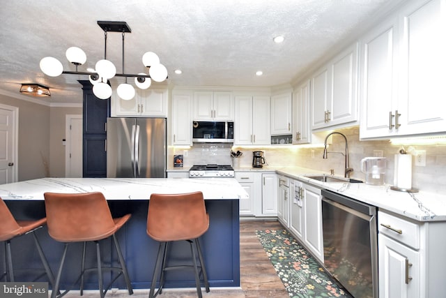 8755 Cather Ave, Manassas, VA 20110 - kitchen with appliances with stainless steel finishes, a sink, wood finished floors, white cabinetry, and a kitchen bar