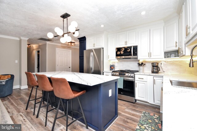 8755 Cather Ave, Manassas, VA 20110 - kitchen with appliances with stainless steel finishes, a sink, a center island, a kitchen bar, and crown molding