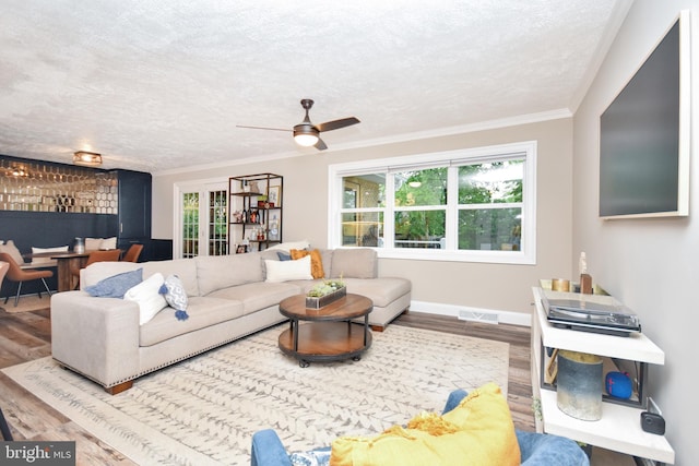 8755 Cather Ave, Manassas, VA 20110 - living room featuring wood finished floors, a textured ceiling, plenty of natural light, ceiling fan, and ornamental molding
