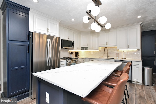 8755 Cather Ave, Manassas, VA 20110 - kitchen with stainless steel appliances, a sink, a kitchen island, a chandelier, and recessed lighting