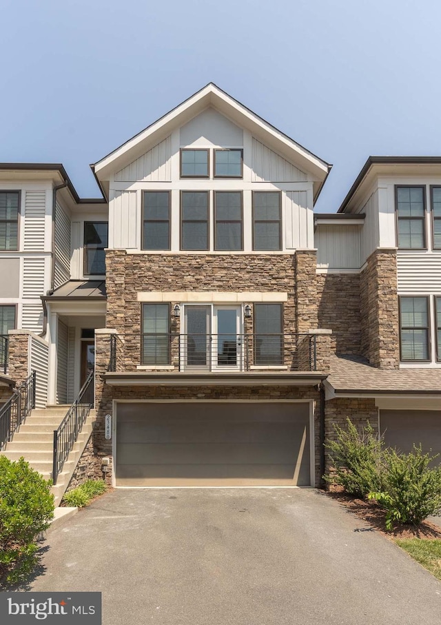 23480 Epperson Sq, Brambleton, VA 20148 - view of front of home with a garage, stone siding, driveway, and board and batten siding