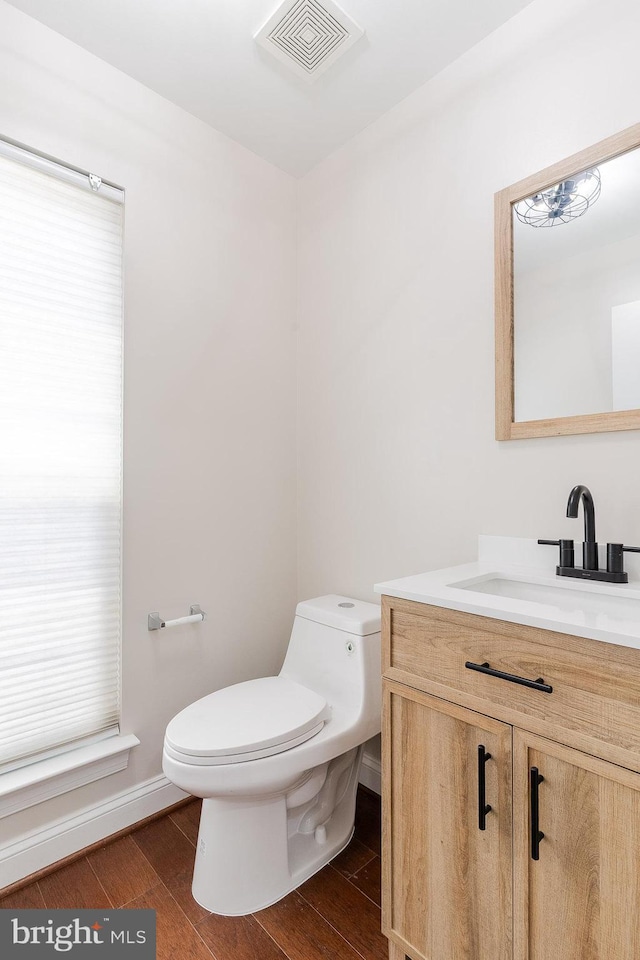 23480 Epperson Sq, Brambleton, VA 20148 - half bathroom with toilet, vanity, wood finished floors, baseboards, and healthy amount of natural light