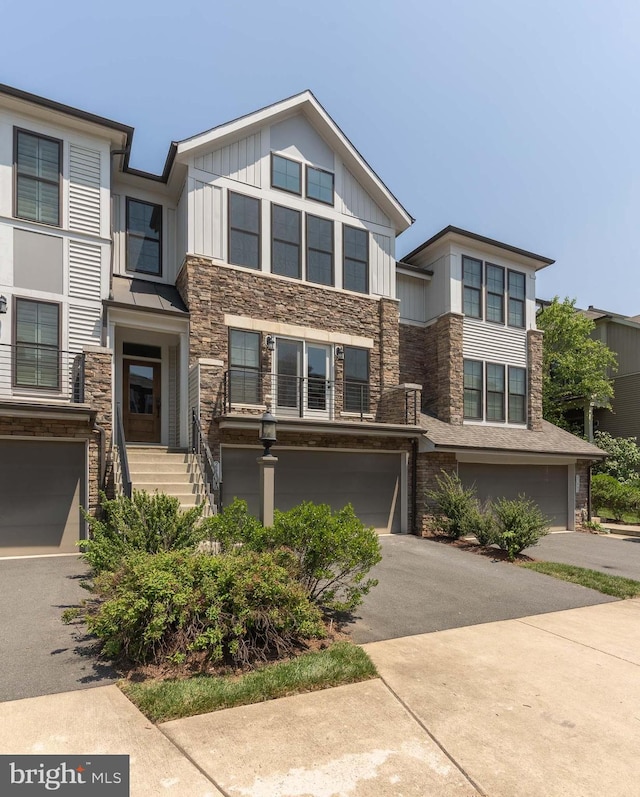 23480 Epperson Sq, Brambleton, VA 20148 - view of front facade featuring stone siding, a garage, board and batten siding, and driveway