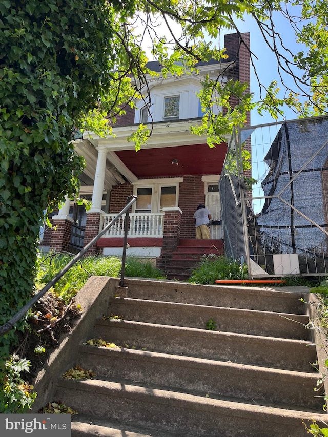 3406 Park Heights Ave, Baltimore, MD 21215 - view of front facade featuring stairway, a porch, brick siding, and a chimney
