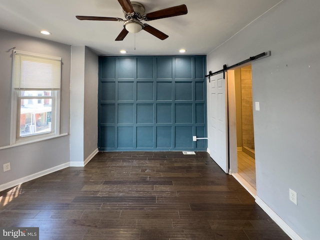 5319 Osage Ave, Philadelphia, PA 19143 - spare room with a decorative wall, a ceiling fan, a barn door, dark wood-style flooring, and recessed lighting