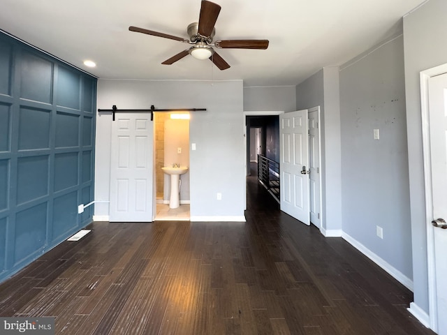 5319 Osage Ave, Philadelphia, PA 19143 - unfurnished bedroom featuring dark wood-type flooring, baseboards, a barn door, and a ceiling fan
