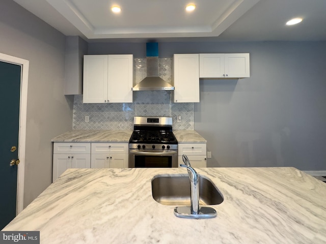 5319 Osage Ave, Philadelphia, PA 19143 - kitchen with wall chimney exhaust hood, stainless steel gas range, a sink, tasteful backsplash, and white cabinetry