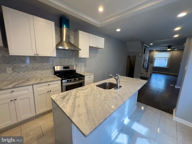 5319 Osage Ave, Philadelphia, PA 19143 - kitchen featuring wall chimney range hood, gas stove, a sink, light tile patterned floors, and recessed lighting