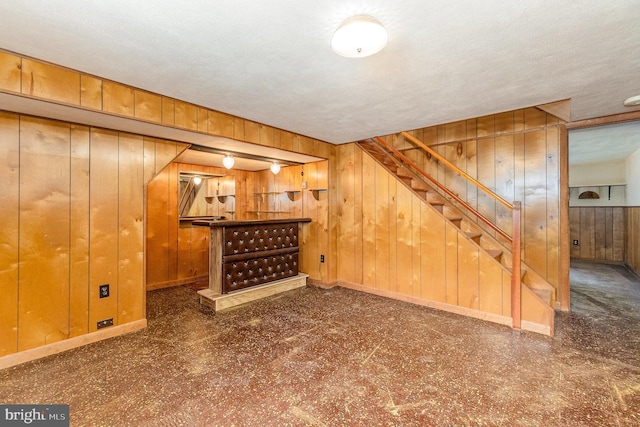 934 Circle Dr, Baltimore, MD 21227 - unfurnished living room with wood walls, a dry bar, and stairs