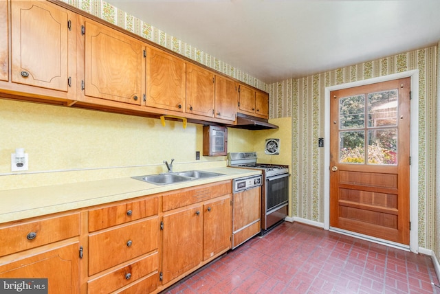 934 Circle Dr, Baltimore, MD 21227 - kitchen with gas range, wallpapered walls, a sink, brick patterned flooring, and baseboards