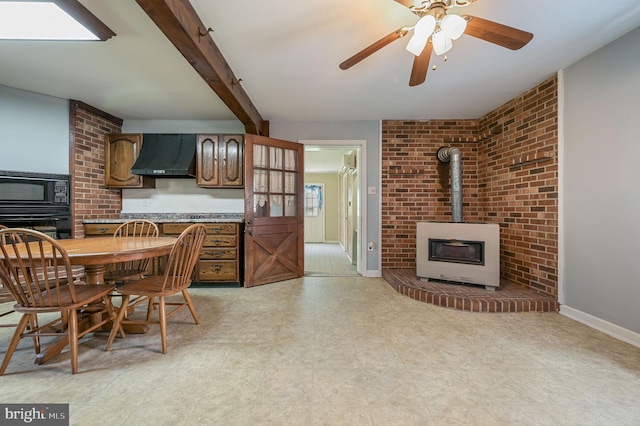 2814 Killens Pond Rd, Harrington, DE 19952 - kitchen with a wood stove, black appliances, exhaust hood, light flooring, and light countertops