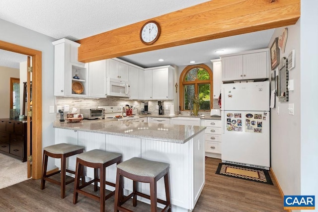 32 Stony Cove Ln, Wintergreen Resort, VA 22967 - kitchen with white appliances, dark wood finished floors, a peninsula, backsplash, and recessed lighting