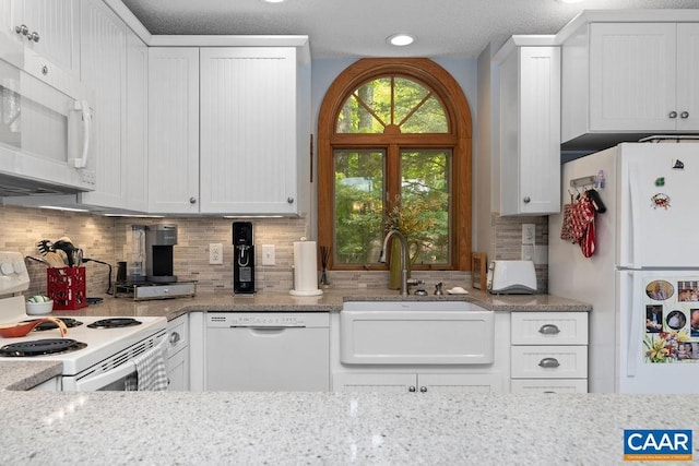 32 Stony Cove Ln, Wintergreen Resort, VA 22967 - kitchen with white appliances, a sink, white cabinets, tasteful backsplash, and light stone counters