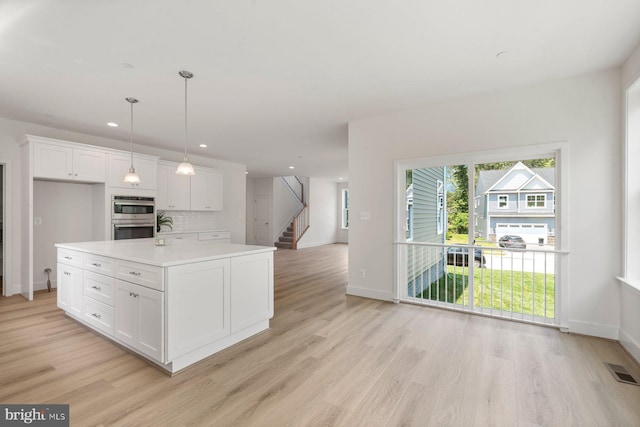 114 Retriever Way, Severna Park, MD 21146 - kitchen with stainless steel double oven, light wood-style flooring, white cabinets, light countertops, and open floor plan