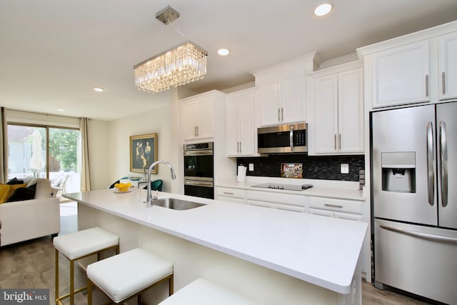 45401 Daveno Sq, Sterling, VA 20164 - kitchen with appliances with stainless steel finishes, a sink, white cabinets, a chandelier, and tasteful backsplash