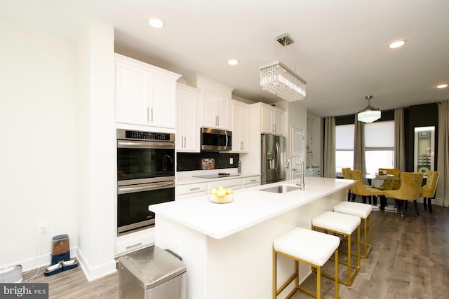 45401 Daveno Sq, Sterling, VA 20164 - kitchen with appliances with stainless steel finishes, a sink, a center island with sink, light countertops, and white cabinets