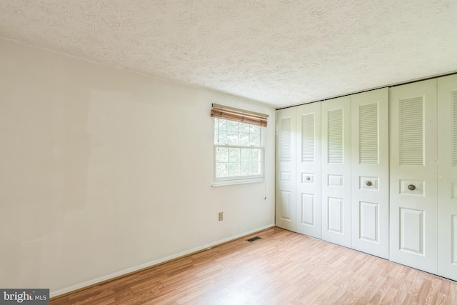 5959 Rowanberry Dr Unit 8E, Elkridge, MD 21075 - unfurnished bedroom featuring wood finished floors, a textured ceiling, baseboards, and a closet