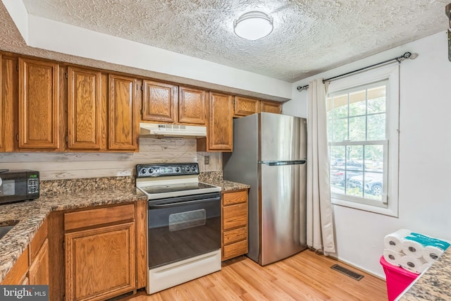 5959 Rowanberry Dr Unit 8E, Elkridge, MD 21075 - kitchen featuring electric stove, freestanding refrigerator, under cabinet range hood, brown cabinets, and black microwave